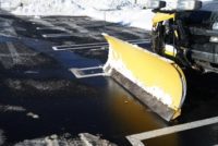 Snow plow in a facility's cleared parking lot