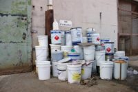 Hazardous Waste containers stacked outside facility